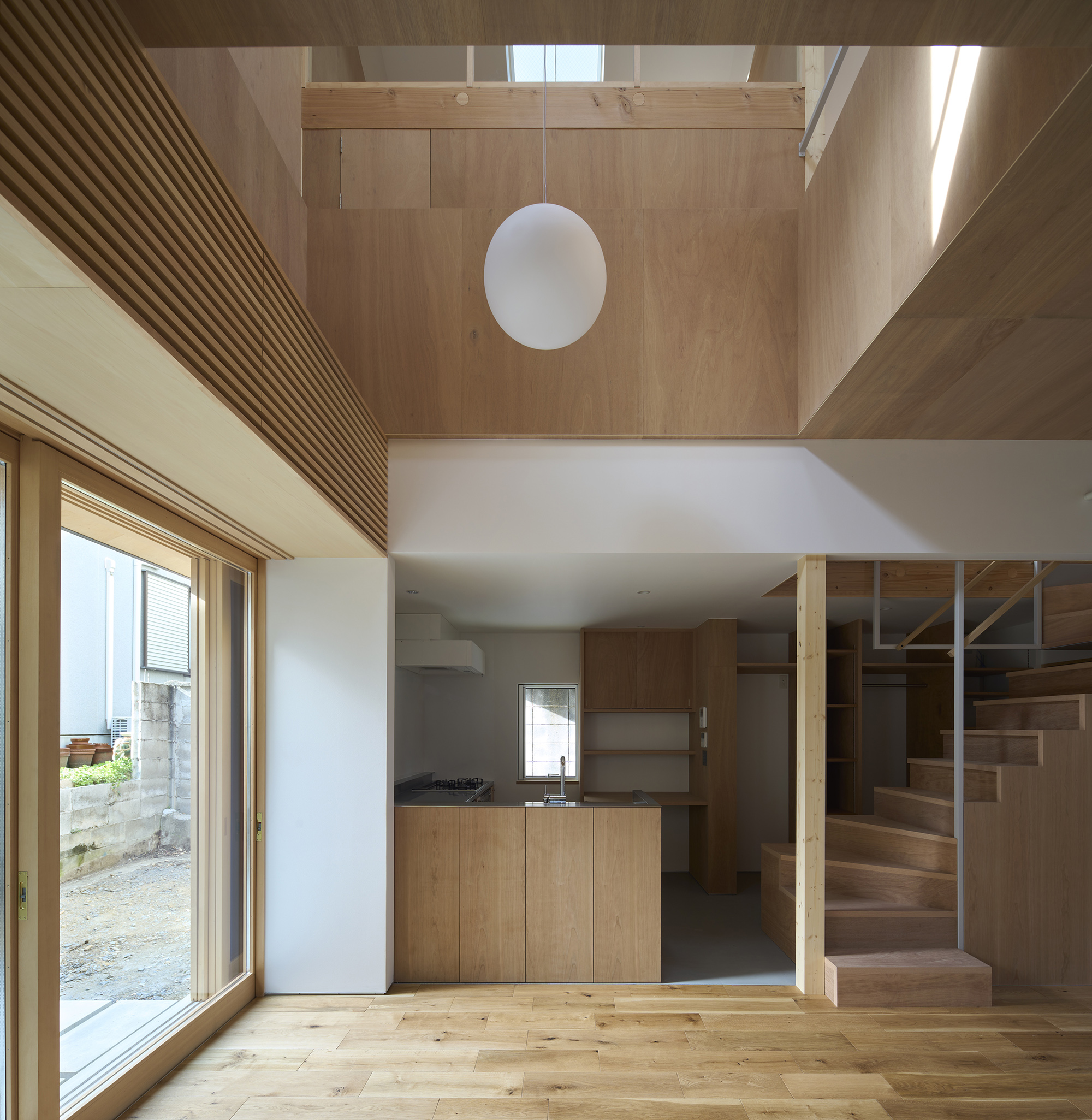 To live in a space accepting certain styles, such as a living room, a kitchen or a Japanese-style room,
or to enjoy unlabeled flexible space actively by changing its use occasionally.
They seem to be contradictory with each other and yet fascinating, and the client seems to be seeking both.
We pursued to combine the richness of them in a space of less than 100 m2, trying to connect the unchanging space with its own character and the space full of possibilities to change according to life cycles, without any sense of discomfort.
The second floor and the loft floor have a split-level arrangement, with nine 3-Tatami grid as the basic unit, each of which can be raised or lowered. The position of the fittings and the difference in levels are adjusted so that the adjacent 3-tatami squares can be connected. We think that these small continuous units of space make the use of house more free than common middle-sized rooms do.
In order to link the individual spaces together, each with its own appropriate design, the sparseness of the lines was used as a cue. The living room and kitchen on the ground floor have a simple composition with a surface that hides unnecessary lines. The living room and kitchen on the ground floor have a simple structure with surfaces that hide unnecessary lines. The upper floors, on the other hand, are full of furniture and objects and are intended to be used in an active and varied way, so the dimensions, heights and positions of the lines are organized. The many lines are planned to serve as supporting lines and visually as details that connect the edges of the divided spaces.
translated by Tota Goya