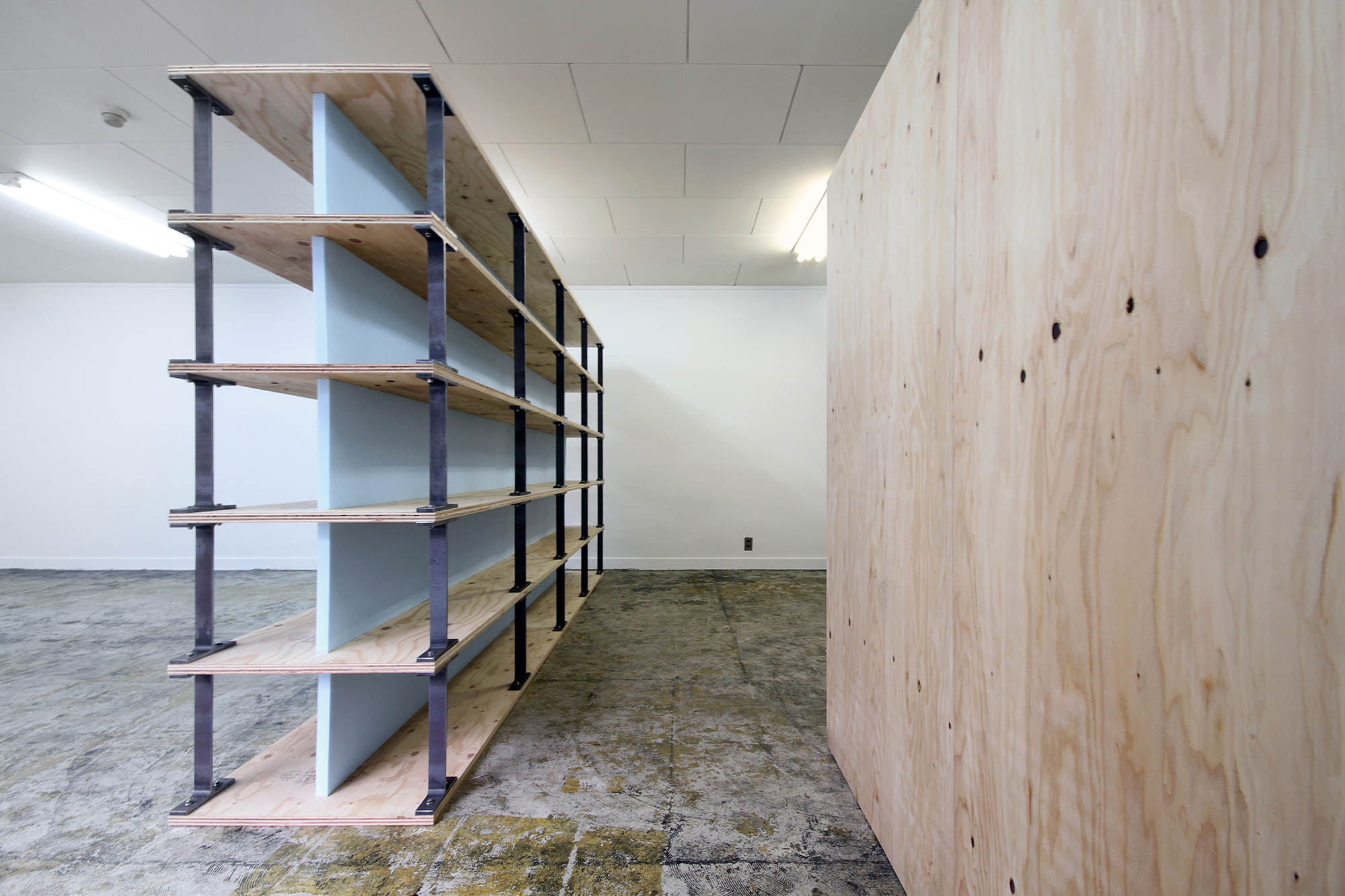 E Design Office, which operates in Kyoto, needed a new interior in their office.
We selected only construction materials by observing its characteristics pragmatically. Those materials normally do not appear on the interior surface. Therefore, their suitable usage for the situation had to be well considered.
Two shelves separate the workspace, meeting space, and backyard softly.
We tried to make a clear space by showing the constructional hierarchy and the relations between the materials in the newly set elements.
translated by Tota Goya